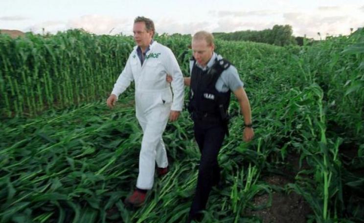 Peter Melchett being led away by a police officer at GM protest