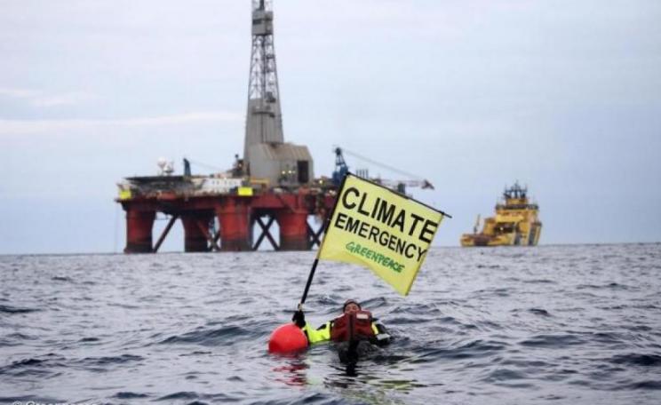 Image: Greenpeace campaigner Sarah North holds a banner reading "Climate Emergency" whilst floating in front of BP oil rig on day 11 of the protest in the North Sea.